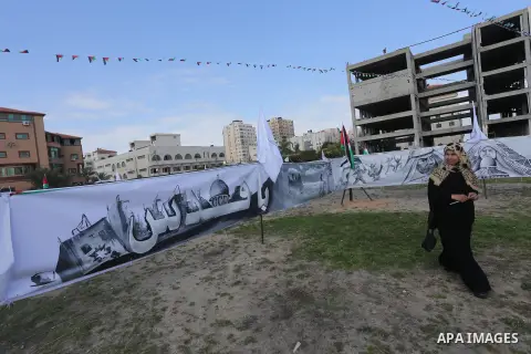 A Palestinian woman walks past a mural during a rally marking Land Day, in Gaza City March 30, 2016. March 30 marks Land Day, the annual commemorations of the killing by police of six Arab citizens in 1976 during protest...