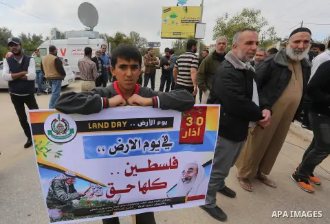 Palestinians hold banners and Palestine flags during a rally marking Land Day, near the Israeli border with northern Gaza Strip March 30, 2016. March 30 marks Land Day, the annual commemorations of the killing by police...