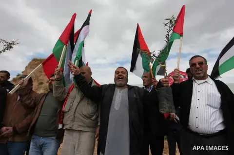 Demonstrators holding Palestinian flags chant slogans during a rally marking Land Day, near the Israeli border with central Gaza Strip March 30, 2016. March 30 marks Land Day, the annual commemorations of the killing by...