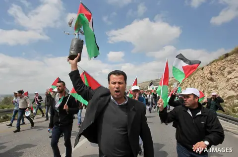 Palestinian demonstrators hold Palestinian flags during a rally marking Land Day in the West Bank village of Burqa near Nablus on March 30, 2016. March 30 marks Land Day, the annual commemorations of the killing by polic...