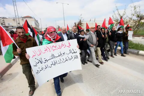 Palestinian protesters hold their national flag during a demonstration to mark Land Day outside the compound of the Israeli-run Ofer prison near Betunia in the Israeli occupied West Bank on March 30, 2016. March 30 marks...