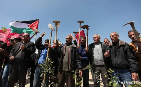 Palestinian protesters wave their national flags during a rally to mark Land Day, near the Nahal Oz crossing east of Gaza City on March 31, 2016. The annual commemorations of the killing by police of six Arab citizens in...
