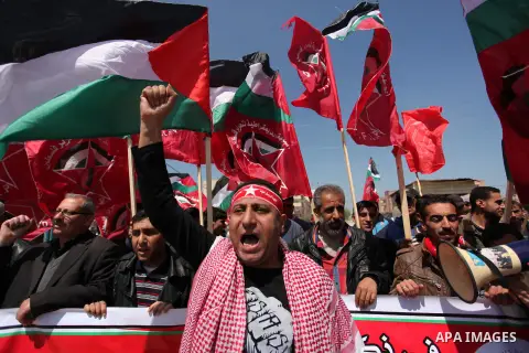 Palestinian protesters wave their national flags during a rally to mark Land Day, near the Nahal Oz crossing east of Gaza City on March 31, 2016. The annual commemorations of the killing by police of six Arab citizens in...