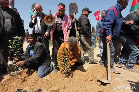 Palestinian protesters plant olive trees during a rally to mark Land Day, near the Nahal Oz crossing east of Gaza City on March 31, 2016. The annual commemorations of the killing by police of six Arab citizens in 1976 du...