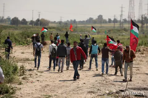 Palestinian protesters wave their national flags during a rally to mark Land Day, near the Nahal Oz crossing east of Gaza City on March 31, 2016. The annual commemorations of the killing by police of six Arab citizens in...