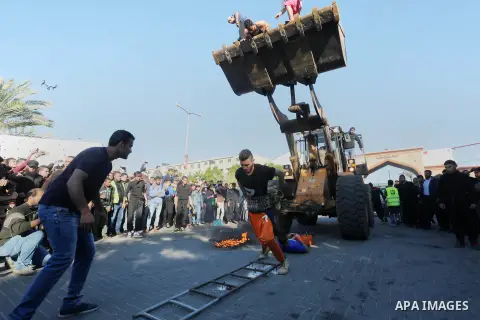 Participants ride in a bulldozer scoop as it is pulled by Palestinian Mohammad Baraka, nicknamed Gaza Samson, during a cultural carnival organized by Gaza Municipality in Gaza City April 1, 2016. Photo by Mohammed Asad