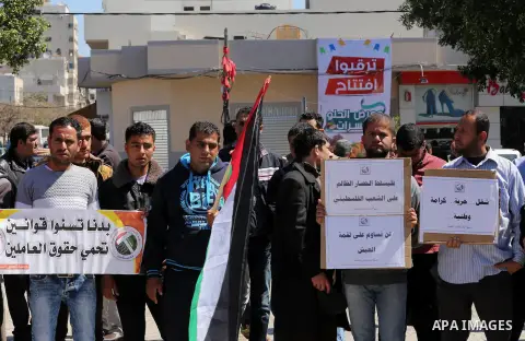 Palestinian supporters of Popular front for Liberation of Palestine (PFLP) hold banners during a protest against the siege of Gaza, in Gaza City, on April 2, 2016. Photo by Mohammed Asad