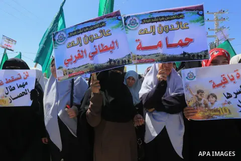 Palestinian women hold banners during a rally marking Land Day, near Eriz crossing in the northern Gaza Strip, on April 2, 2016. Photo by Yasser Qudih
