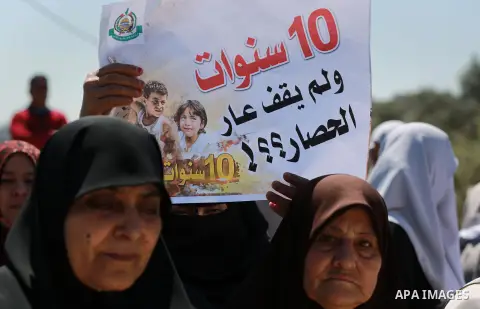 Palestinian women hold banners during a rally marking Land Day, near Eriz crossing in the northern Gaza Strip, on April 2, 2016. Photo by Yasser Qudih