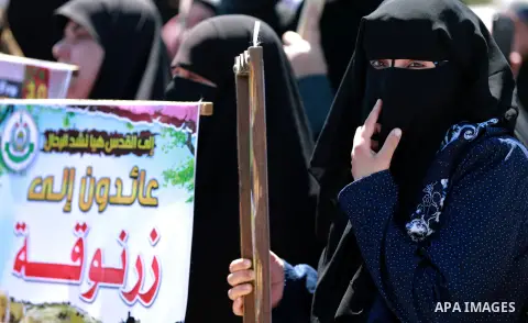 Palestinian women hold banners during a rally marking Land Day, near Eriz crossing in the northern Gaza Strip, on April 2, 2016. Photo by Yasser Qudih