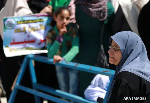Palestinian women hold banners during a rally marking Land Day, near Eriz crossing in the northern Gaza Strip, on April 2, 2016. Photo by Yasser Qudih