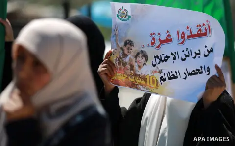 Palestinian women hold banners during a rally marking Land Day, near Eriz crossing in the northern Gaza Strip, on April 2, 2016. Photo by Yasser Qudih