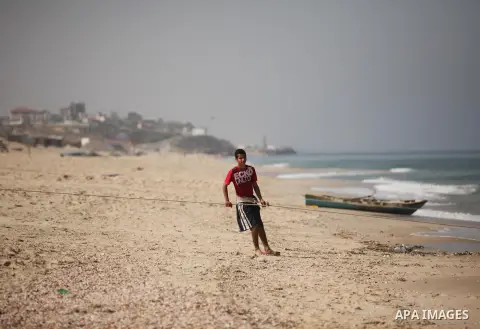 Palestinian fishermen pull their net at the beach in Gaza City on April 03, 2016. Israel on Sunday extended the distance it permits Gaza fishermen to head out to sea along certain parts of the coastline of the enclave, w...
