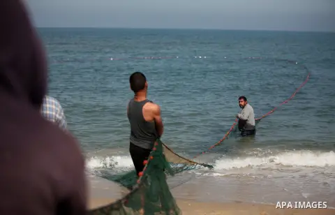 Palestinian fishermen pull their net at the beach in Gaza City on April 03, 2016. Israel on Sunday extended the distance it permits Gaza fishermen to head out to sea along certain parts of the coastline of the enclave, w...