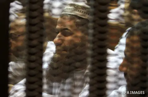 Muslim Brotherhood members sit behind the defendants cage as they attend their trial along with Egyptian Muslim Brotherhood leader Mohammed Badie (unseen), at a court in the outskirts of Cairo, Egypt, on April 03, 2016....