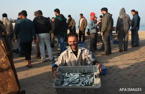 A Palestinian fisherman displays fish for sale, in Gaza seaport, on April 4, 2016. Israel on Sunday extended the distance it permits Gaza fishermen to head out to sea along certain parts of the coastline of the enclave,...