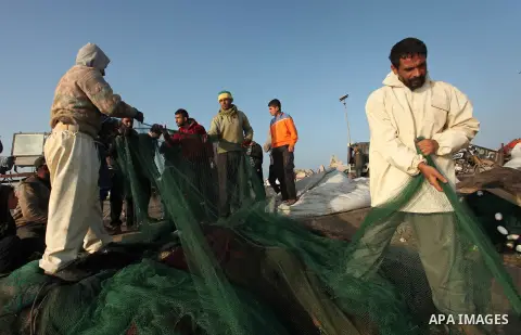 Palestinian fishermen pull their net at the beach in Gaza City, on April 4, 2016. Israel on Sunday extended the distance it permits Gaza fishermen to head out to sea along certain parts of the coastline of the enclave, w...