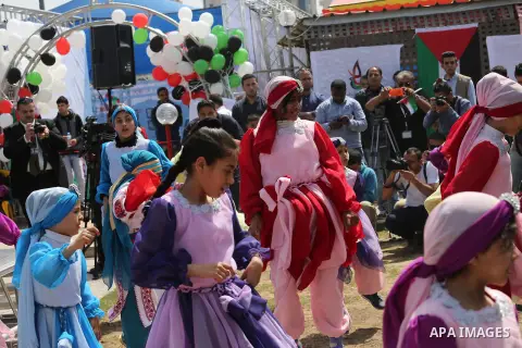 Palestinian children take part in a ceremony to mark Palestinian child day in Gaza seaport, on April 6, 2016. Photo by Mohammed Asad