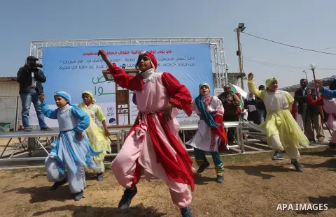 Palestinian children take part in a ceremony to mark Palestinian child day in Gaza seaport, on April 6, 2016. Photo by Mohammed Asad