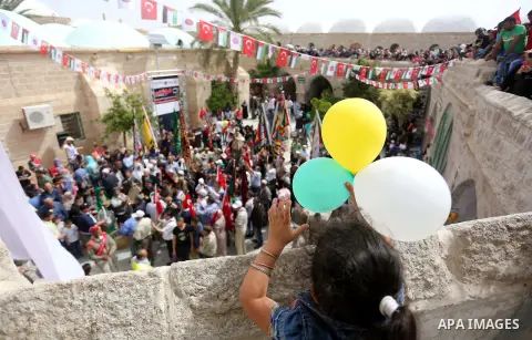 Palestinians attend a festival at the mosque of Nabi Musa, where the tomb of Prophet Moses is believed to be placed, in the Judean Desert neat the West Bank town of Jericho, on April 8, 2016. The festival sponsored by th...