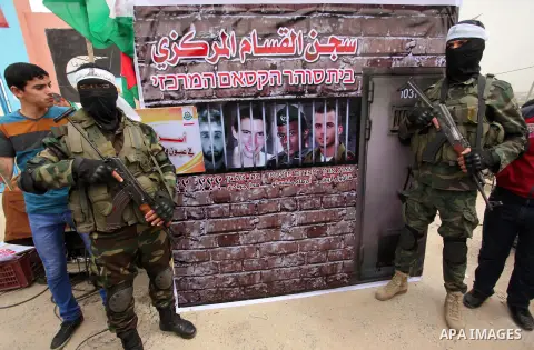 Members of the Ezzedine al-Qassam Brigades, the military wing of the Palestinian Islamist movement Hamas take part during a protest demanding release the prisoners in Israeli jails at the Erez crossing checkpoint in the...