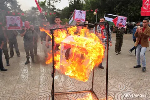 Supporters of the Popular Front for the Liberation of Palestine (PFLP) burn a poster of Palestinian President Mahmoud Abbas during a protest against Abbas's policies, in Gaza City April 12, 2016. The poster reads, "Leave...