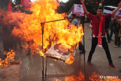 Supporters of the Popular Front for the Liberation of Palestine (PFLP) burn a poster of Palestinian President Mahmoud Abbas during a protest against Abbas's policies, in Gaza City April 12, 2016. The poster reads, "Leave...