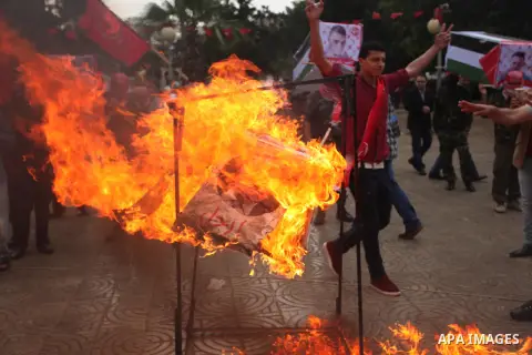 Supporters of the Popular Front for the Liberation of Palestine (PFLP) burn a poster of Palestinian President Mahmoud Abbas during a protest against Abbas's policies, in Gaza City April 12, 2016. The poster reads, "Leave...