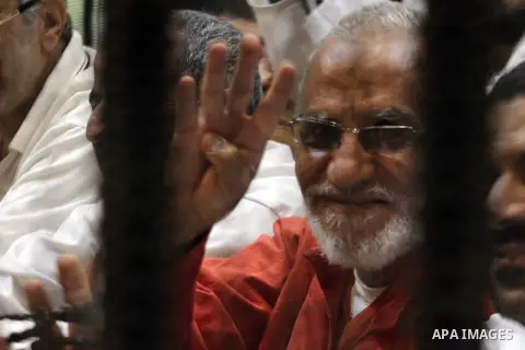 Egyptian Muslim Brotherhood leader Mohammed Badie sits behind the defendant's cage as he attends his trial, at a court in the outskirts of Cairo, Egypt, on April 12, 2016. Photo by Stranger