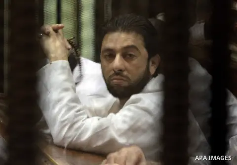 Muslim Brotherhood members sit behind the defendants cage as they attend their trial along with Egyptian Muslim Brotherhood leader Mohammed Badie (unseen), at a court in the outskirts of Cairo, Egypt, on April 12, 2016....