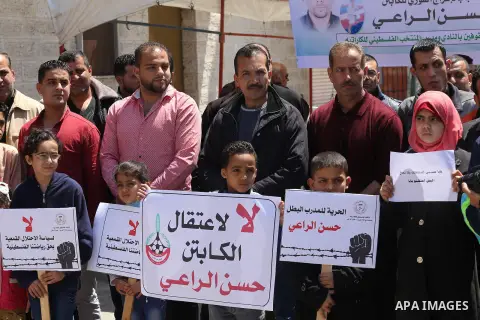 Palestinians hold banners during a protest in solidarity with the karate trainer, Hassan El-Raey against his arrest by the Israeli army, in front of Red cross office in Gaza city on April 13, 2016. Photo by Mohammed Asad