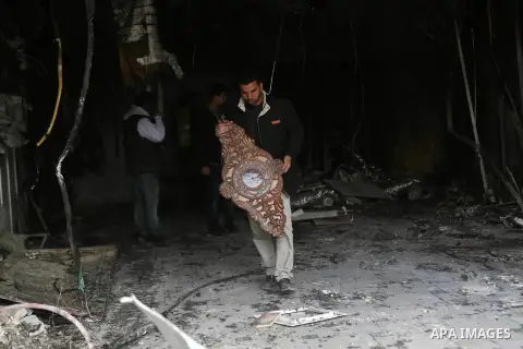 Palestinians check a money changer in the Palestinian political capital Ramallah after it was raided by Israeli forces, blowing up a safe and sparking a fire, on April 14, 2016. An Israeli army spokeswoman said the pre-d...