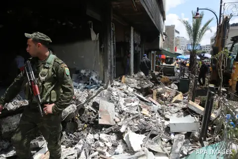 A member of Palestinian security forces walks outside at a money changer in the Palestinian political capital Ramallah after it was raided by Israeli forces, blowing up a safe and sparking a fire, early on April 14, 2016...