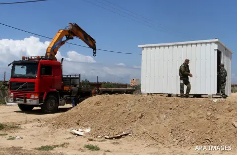 Palestinian workers place containers as new sites for Palestinian security forces in front of the Gaza-Egypt border in Rafah in the southern Gaza Strip, on April 14, 2016. Senior Hamas leader Ismail Haniyeh confirmed tha...