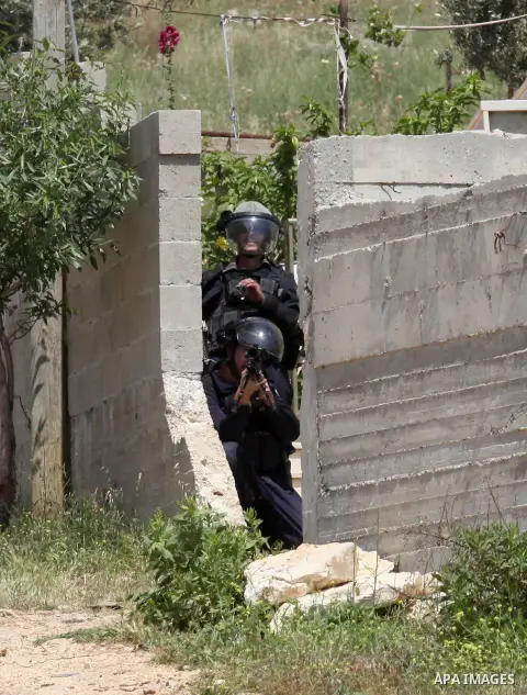 Israeli security forces take aim as they hold a position during clashes with Palestinian protesters following a weekly demonstration against the expropriation of Palestinian land by Israel in the village of Kfar Qaddum,...