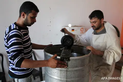 Palestinian beekeepers remove trays from a beehive to collect honey at a honey-bee farm in Bureij Refugee Camp, central Gaza Strip, on April 16, 2016. Beekeepers collect honey and wax from the beehives at this time of ye...