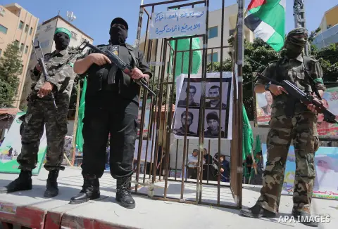 Members of the Ezzedine al-Qassam Brigades, the military wing of the Palestinian Islamist movement Hamas, stand next to mock jails during a rally marking Palestinian Prisoner Day in Gaza City on April 17, 2016. Photo by...