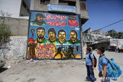 Palestinian men look graffiti marking Palestinian Prisoner Day in Gaza City on April 17, 2016. Photo by Mohammed Asad