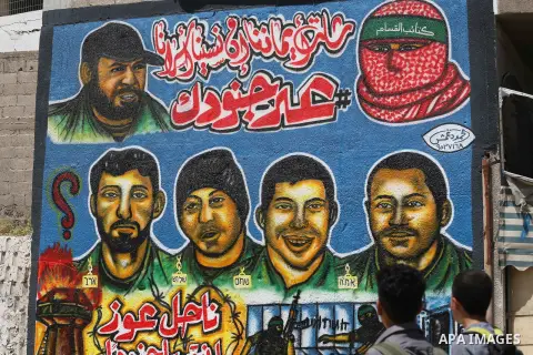 Palestinian men look graffiti marking Palestinian Prisoner Day in Gaza City on April 17, 2016. Photo by Mohammed Asad