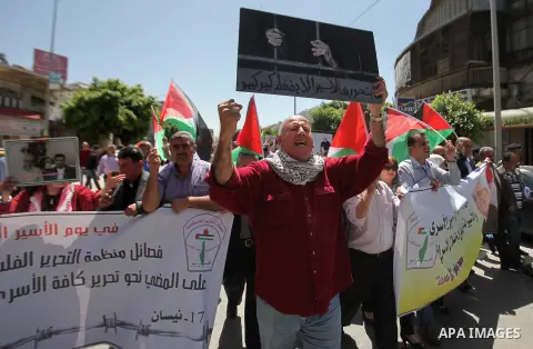 Palestinians hold pictures of Palestinians detained in Israeli prisons during a demonstration to mark Palestinian Prisoner Day in the West Bank city of Nablus on April 17, 2016. Photo by Nedal Eshtayah