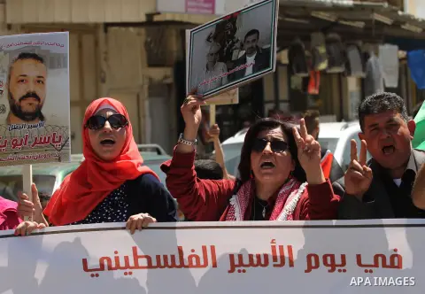 Palestinians hold pictures of Palestinians detained in Israeli prisons during a demonstration to mark Palestinian Prisoner Day in the West Bank city of Nablus on April 17, 2016. Photo by Nedal Eshtayah