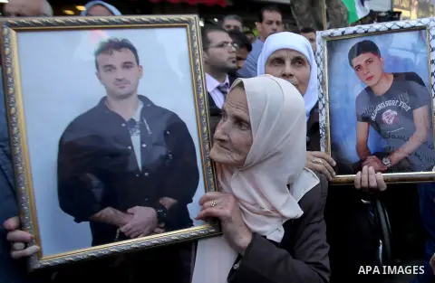 Palestinians hold pictures of Palestinians detained in Israeli prisons during a demonstration to mark Palestinian Prisoner Day in the West Bank city of Nablus on April 17, 2016. Photo by Nedal Eshtayah