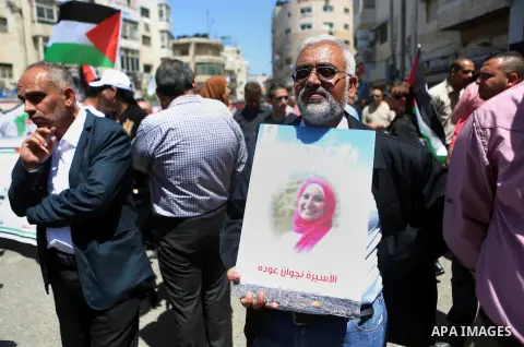 Palestinians hold pictures of Palestinians detained in Israeli prisons during a demonstration to mark Palestinian Prisoner Day in the West Bank city of Ramallah on April 17, 2016. Photo by Shadi Hatem