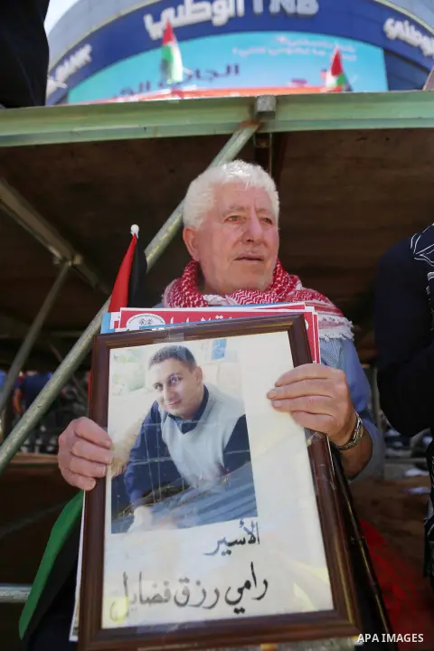 Palestinians hold pictures of Palestinians detained in Israeli prisons during a demonstration to mark Palestinian Prisoner Day in the West Bank city of Ramallah on April 17, 2016. Photo by Shadi Hatem
