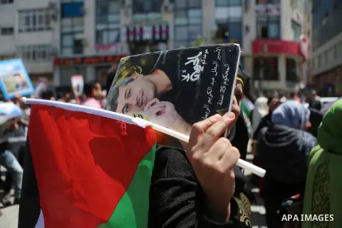 Palestinians hold pictures of Palestinians detained in Israeli prisons during a demonstration to mark Palestinian Prisoner Day in the West Bank city of Ramallah on April 17, 2016. Photo by Shadi Hatem