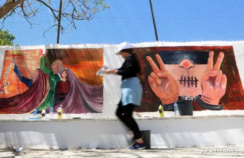 A Palestinian artist paints graffiti at school to mark Palestinian Prisoner Day in the West Bank city of Ramallah on April 17, 2016. Photo by Shadi Hatem
