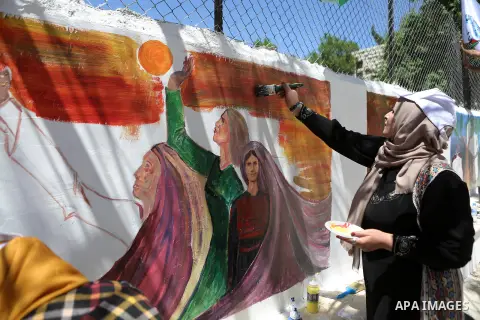 A Palestinian artist paints graffiti at school to mark Palestinian Prisoner Day in the West Bank city of Ramallah on April 17, 2016. Photo by Shadi Hatem