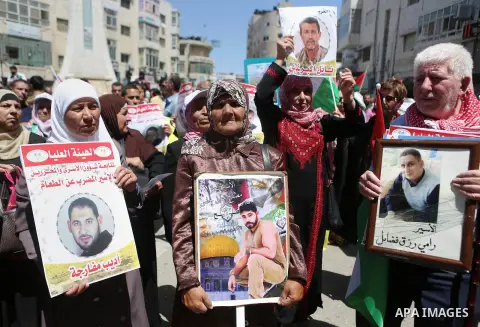 Palestinians hold pictures of Palestinians detained in Israeli prisons during a demonstration to mark Palestinian Prisoner Day in the West Bank city of Ramallah on April 17, 2016. Photo by Shadi Hatem