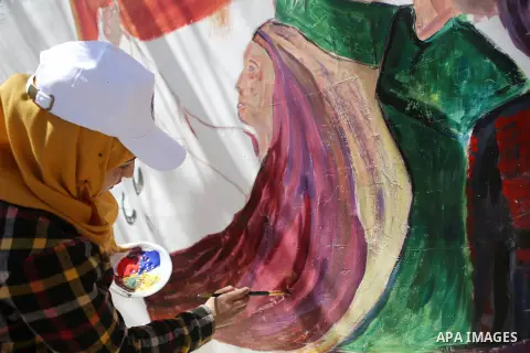 A Palestinian artist paints graffiti at school to mark Palestinian Prisoner Day in the West Bank city of Ramallah on April 17, 2016. Photo by Shadi Hatem