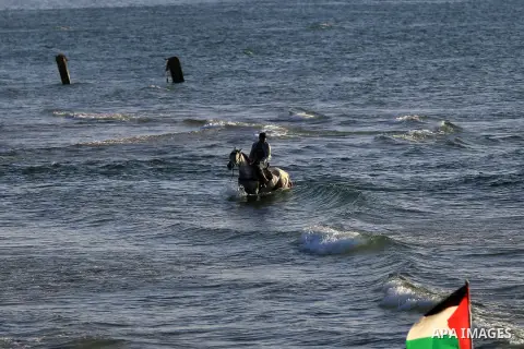 A Palestinian man rides a horse during sunset at the beach of the Mediterranean sea on the coast of Gaza city on April 17, 2016. Photo by Yasser Qudih